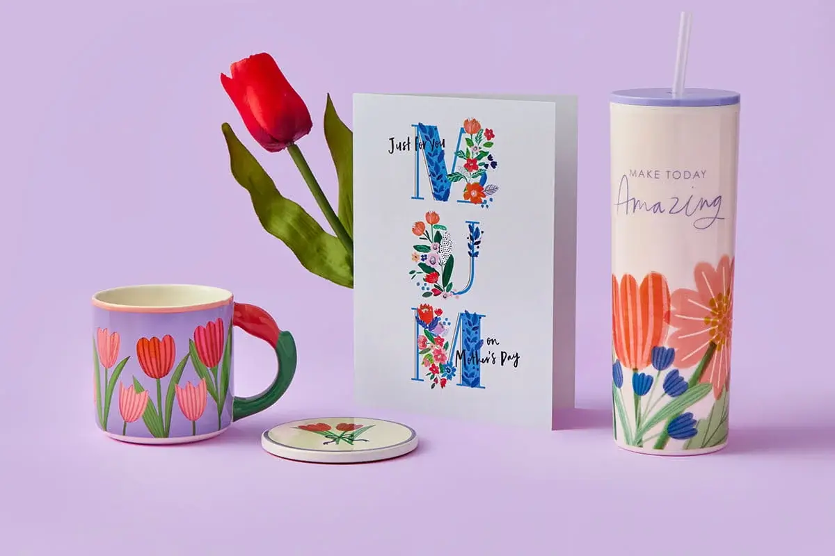 A floral Mother’s Day set featuring a pastel jug filled with pink and orange flowers, a butterfly‑decorated Grandma mug, and a garden‑themed Mum card arranged on a pastel purple background. A floral Mother’s Day set featuring a pastel jug filled with pink and orange flowers, a butterfly‑decorated Grandma mug, and a garden‑themed Mum card arranged on a pastel purple background.
